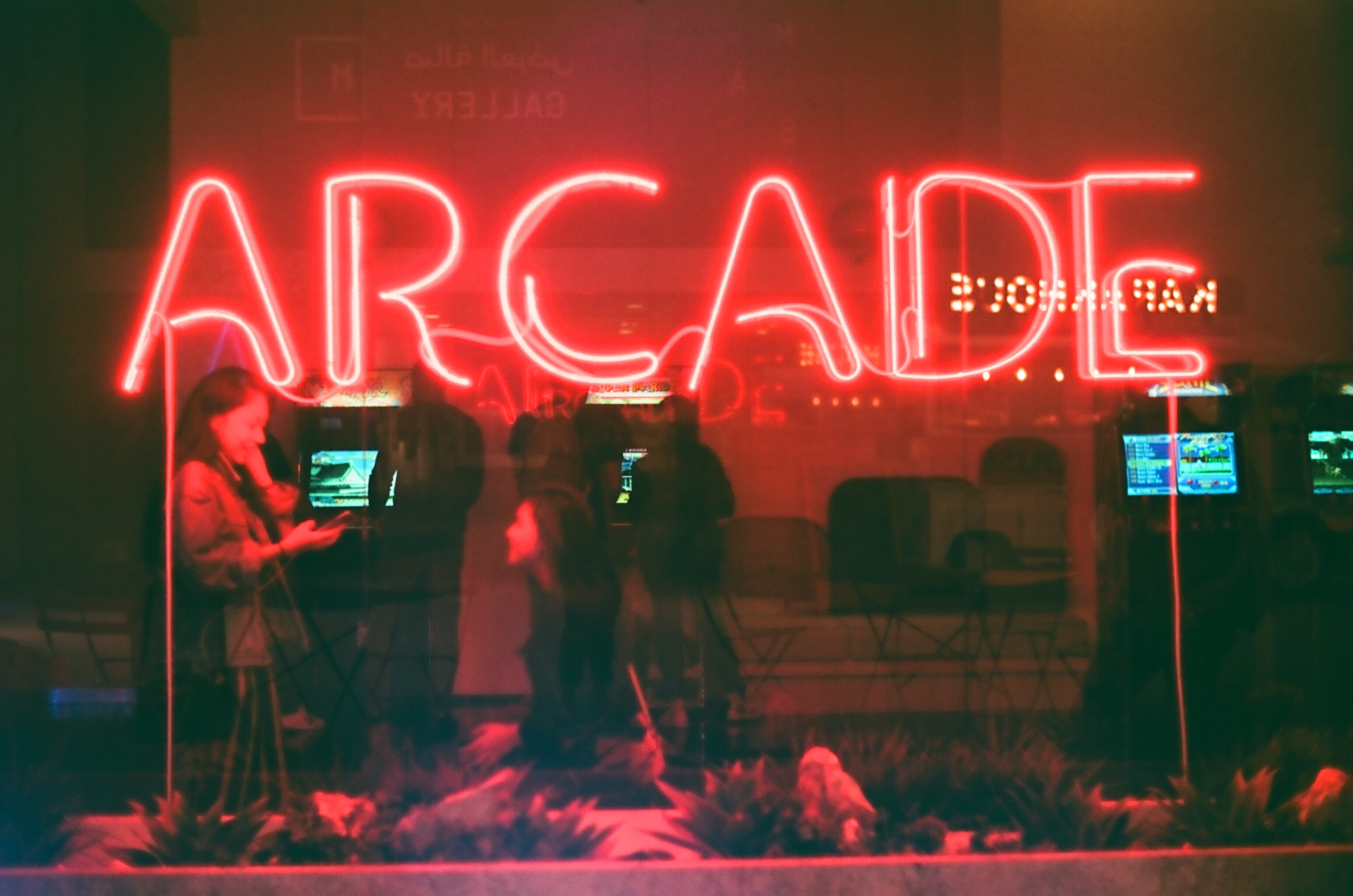 A neon red sign that reads, 'Arcade'. 