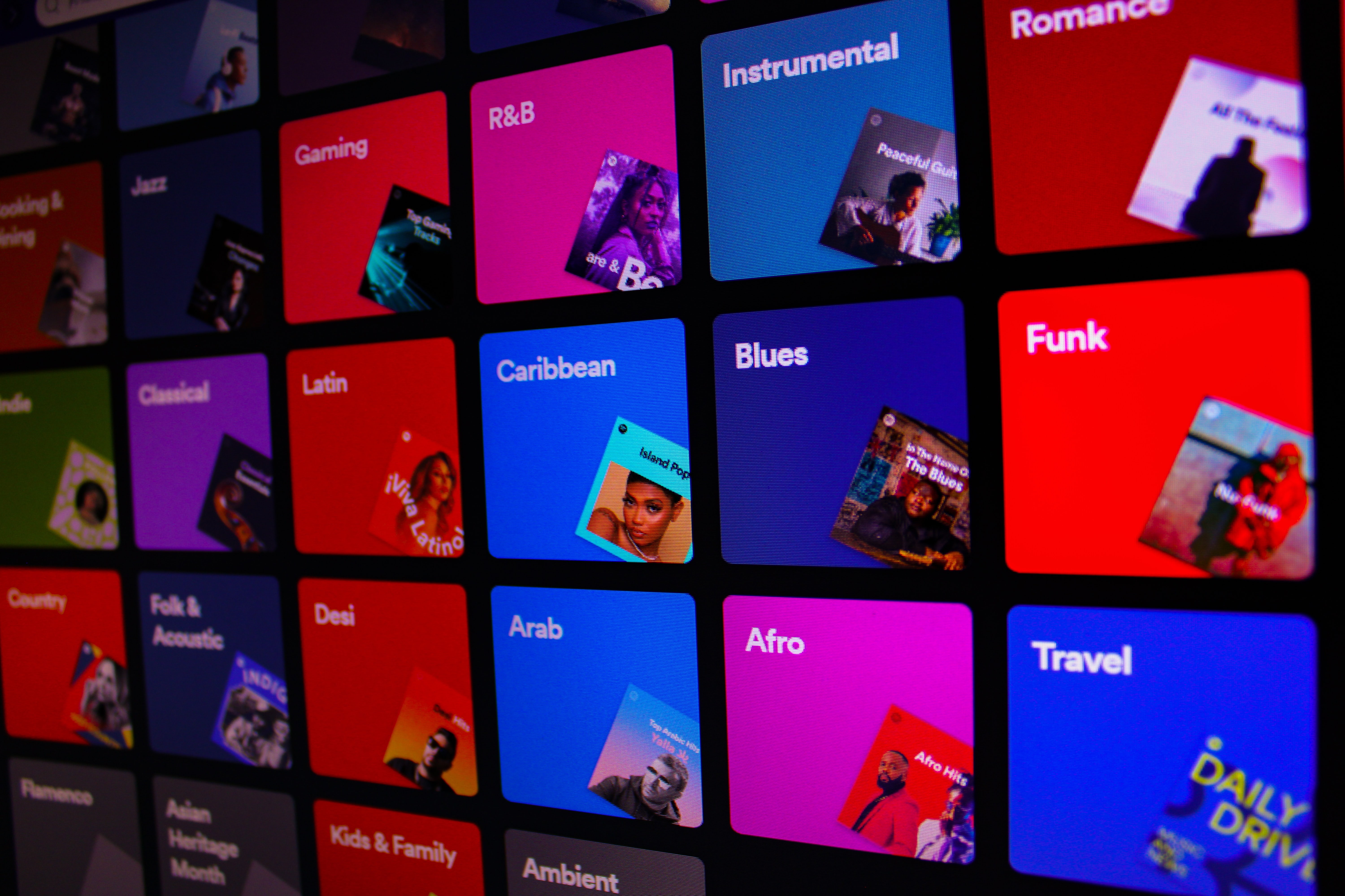 Spotify genre tiles are displayed as a background.