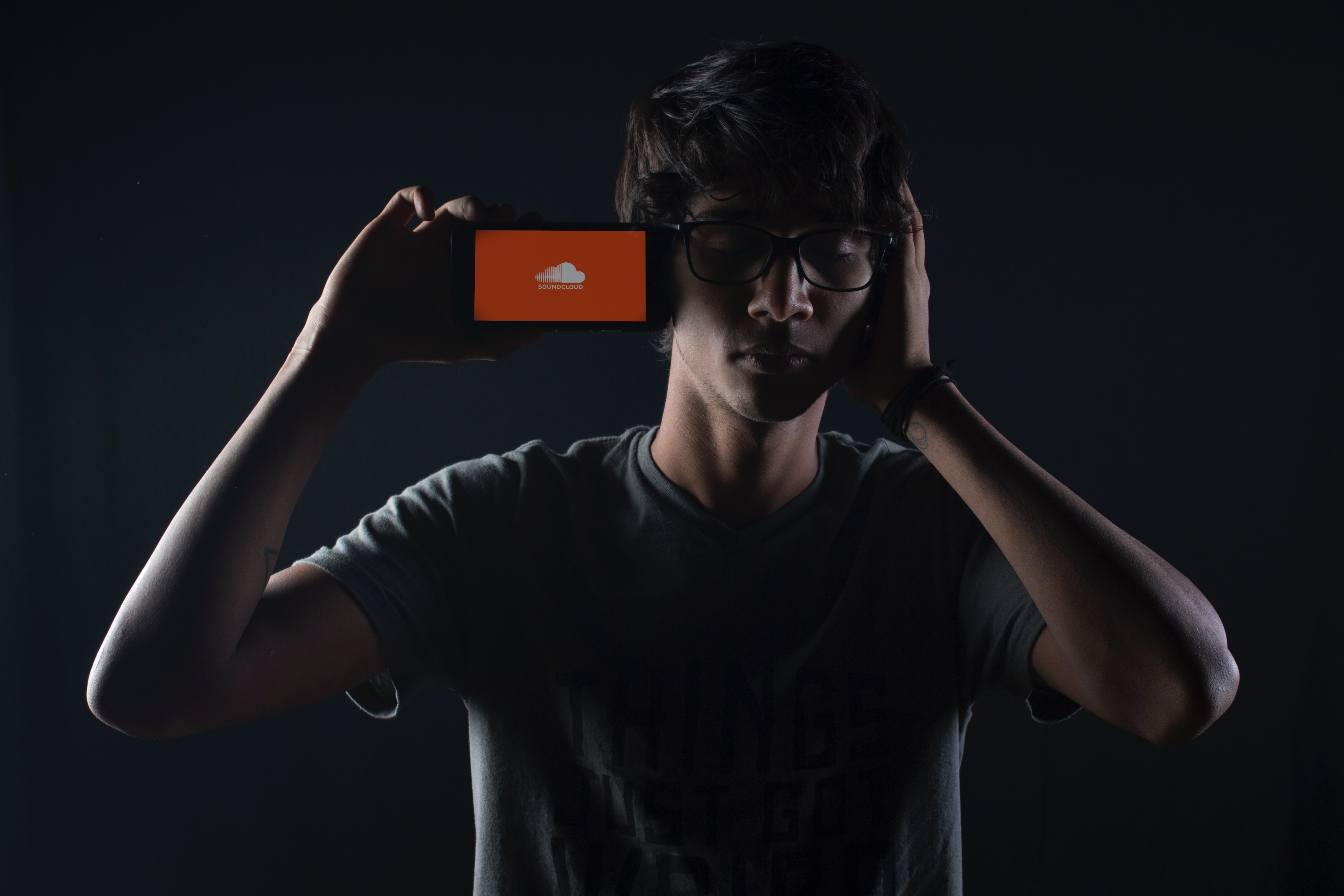 A man listening to SoundCloud on his iPhone